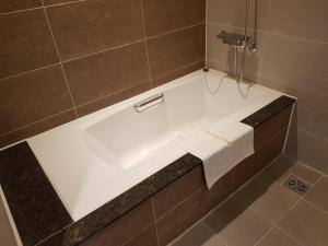 釜山Suntree Hotel的瓷砖浴室设有白色浴缸。