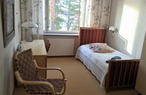 耶姆赛Club House Hotelli Kaipolan Ranta的一间卧室配有一张床、一张书桌和一个窗户。