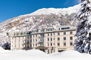 蓬特雷西纳蓬特雷西纳运动酒店的一座有雪盖的建筑,背景是一座山
