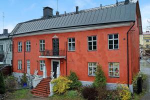 波尔沃Remuganes suite - Porvoon Linna的一座橙色的建筑,设有黑色的屋顶和楼梯