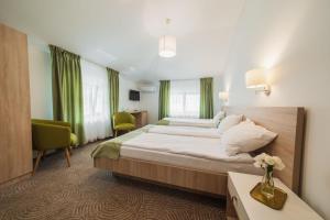 克利默内什蒂达达特玛尔酒店的酒店客房设有一张大床和绿色窗帘