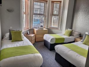 伯恩茅斯切尔西酒店的客房 - 带两张带绿色和白色床单的床