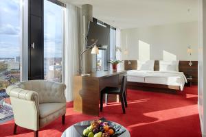 汉堡帝王河畔酒店的酒店客房配有书桌、床和桌子。