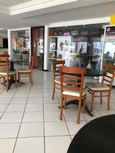 塔曼达雷APART HOTEL MARINAS TAMANDARÉ - Flat 104的商店里带木椅和桌子的餐厅