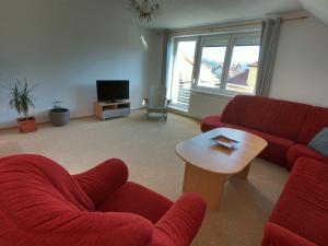 利普托斯基米库拉斯Apartment Amy的客厅配有两张红色的沙发和一张桌子