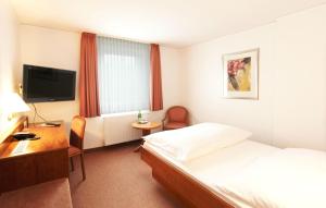 卡尔斯特米歇尔斯加尼兰德豪斯酒店的酒店客房配有一张床、一张书桌和一台电视。