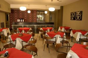 圣地亚哥-德尔埃斯特罗中心酒店的餐厅设有红色和白色的桌椅