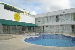蒙特里亚Hotel Calarca Club的大楼前设有游泳池的酒店