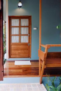清迈Paiyannoi Guesthome的一间设有木门和木椅的客房