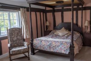 贝里圣埃德蒙兹St Mary’s Bed & Breakfast的一间卧室配有四柱床和椅子