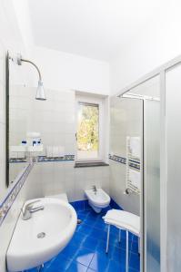 马奥莱多特里住宅酒店的白色的浴室设有水槽和卫生间。