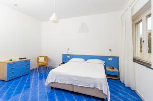 马奥莱多特里住宅酒店的蓝色和白色的卧室,配有床和椅子
