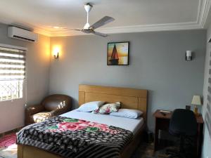 阿克拉Bonsukoda Lodge的一间卧室配有一张床和吊扇