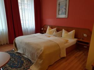 霍夫库伯根酒店的一间卧室设有一张带红色墙壁的大床