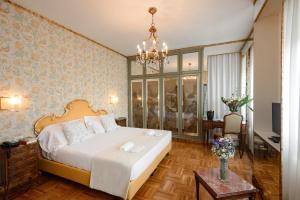 特雷维索欧陆酒店的一间卧室配有一张大床和一个吊灯。