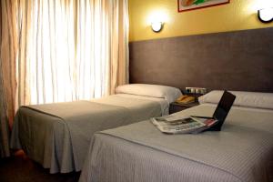 穆尔西亚Hotel Universal Murcia的酒店客房,配有两张床和椅子