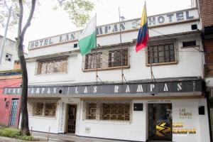 麦德林Hotel Las Rampas的前面有两面旗帜的建筑