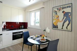 达沃斯Studio 25 Davos Platz的厨房配有桌椅和墙上的绘画作品