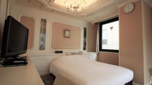 东京新大久保皇家酒店的一间卧室设有一张床、一台电视和一个窗口。