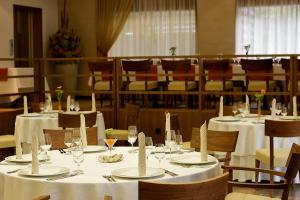 伊德里亚约瑟夫酒店的用餐室配有桌椅和白色的桌布
