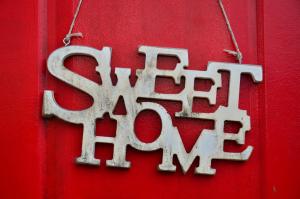 迪利然Sweet Home的红色门上的金属标志,上面写着庇护一词