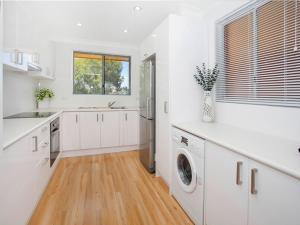 凯阿玛Waves Appartment的厨房配有白色橱柜、洗衣机和烘干机