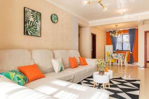 开封河南省开封市·河南大学·路客精品公寓·00140700的客厅配有白色沙发和橙色枕头。