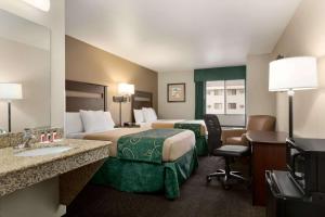 格伦代夫Baymont by Wyndham Glendive的酒店客房带两张床和一间浴室