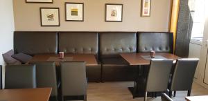 霍夫阿特西酒店的餐厅设有两张桌子和一张皮沙发