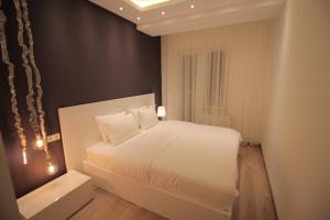 第比利斯Super Luxury Apartments的卧室配有白色的床和黑色墙壁