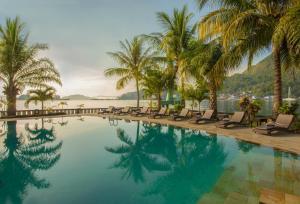 查亚普拉瑞士贝尔帕普亚酒店的一个带躺椅和棕榈树的游泳池