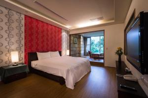 乌来乌来淞吕温泉会馆的一间卧室配有一张床和一台平面电视