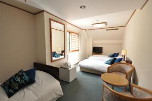 白马村白马山野酒店的一间卧室配有两张床、一张桌子和一把椅子