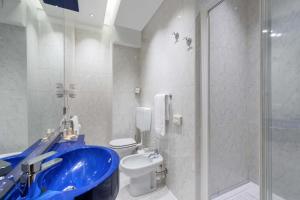 维罗纳Mastino Rooms的浴室配有蓝色水槽和卫生间。
