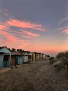 西威特灵The Beach House的日落时在海滩上排排的海滩小屋