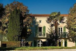 圣马丹德雷Appartement 91 Palais des Gouverneurs的一座大房子,前面有棕榈树