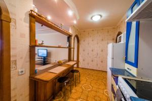 托木斯克Большая Подгорная 57 квартира-студия с утепленной лоджией的小客房配有书桌和冰箱。