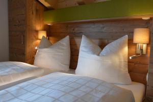 施特格Pension Alpenblick的一间卧室配有两张带白色枕头的床