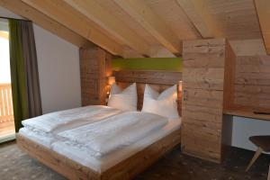 施特格Pension Alpenblick的一间卧室配有一张带木制床头板的床