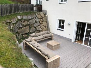 卡普伦AlpinResort Kaprun 1的一个带两张沙发和石墙的庭院