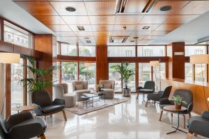 里斯本多姆卡洛斯自由酒店的一间设有桌椅和窗户的等候室