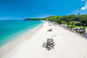 圣约翰斯Sandals Grande Antigua - All Inclusive Resort and Spa - Couples Only的海滩上设有椅子和遮阳伞,还有大海