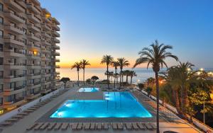 多列毛利诺斯Apto a pie de playa con vistas increíbles!的一座棕榈树游泳池和一座建筑