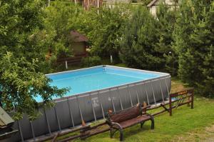 斯拉夫西克Kovalska Sadyba的庭院内的游泳池,带长凳