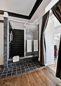 尤里卡斯普林斯New Orleans Hotel Eureka Springs的浴室设有步入式淋浴间和黑色瓷砖