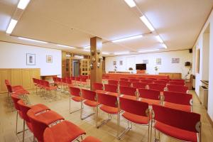 圣马蒂诺-迪卡斯特罗扎GH Hotel Fratazza的一间会议室,配有红色椅子和讲台