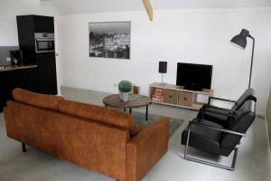 Noord-Sleenons huusie的客厅配有棕色沙发和两把椅子