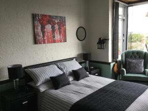 布里德波特Southcroft的一间卧室配有一张床和一把绿色椅子