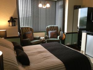 布里德波特Southcroft的酒店客房,配有一张床和两把椅子