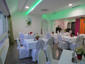 卡什泰拉芭蕾舞学校酒店的宴会厅配有白色的桌子和白色的椅子